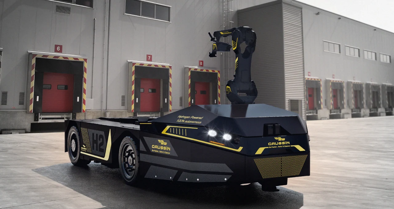 Véhicule Gaussin H2 équipé d’un bras robotisé, devant les quais d’un bâtiment logistique.